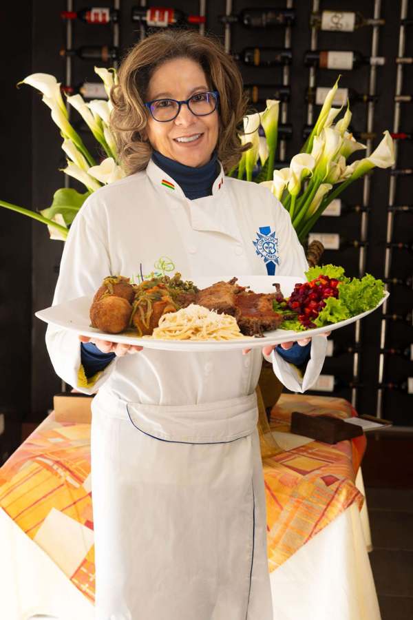 Charito sosteniendo una bandeja de platos de la casa